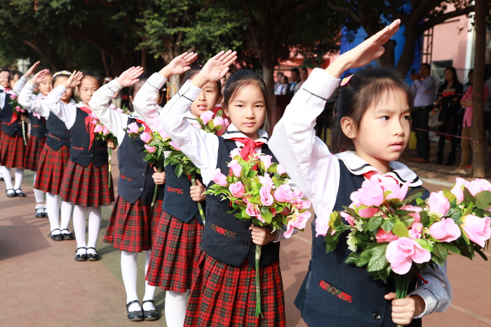 04、圖為鮮花隊(duì)的同學(xué)在升國(guó)旗儀式時(shí)向國(guó)旗敬禮